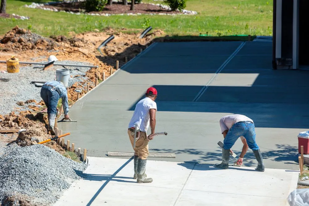 contractors leveling the freshly poured concrete mixture to create a driveway in Sparks, NV